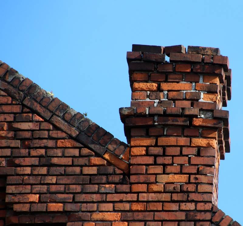 Damaged chimney on an Downers Grove home showing cracks and missing mortar